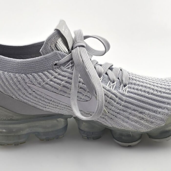 Side view of vintage sneakers NIKE Air Vapormax Flyknit 3 in grey with visible air sole unit